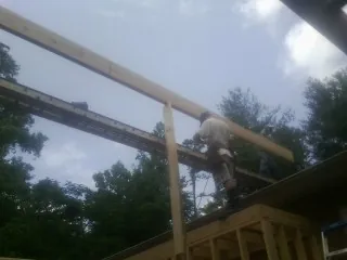 Carpenter setting a ridge beam over a new addition frame — Ice Dam Removal by Roofing Brothers in Waterford Works