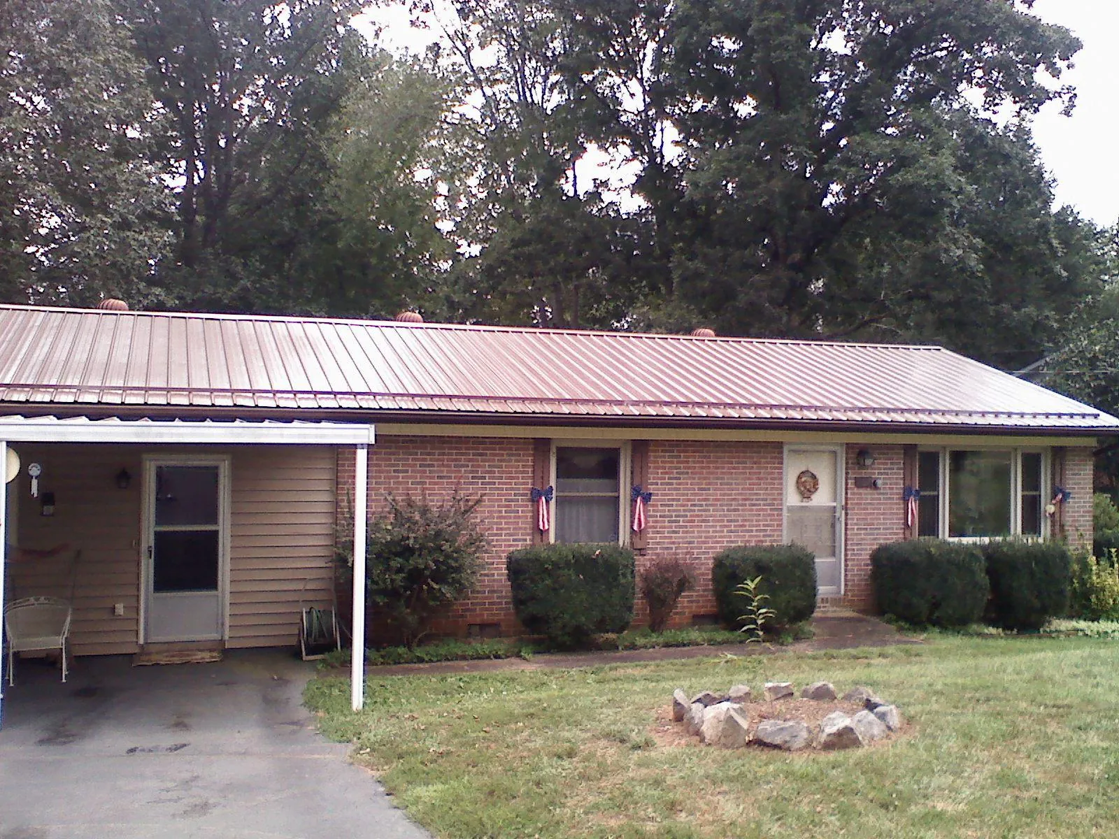 Bronze metal roof and carport on a brick ranch home — Roof Repair work by our crew in Waterford Works